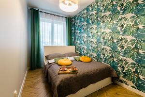 1 dormitorio con 1 cama con papel pintado verde y blanco en Apartament Rezydencja Vintage No2, en Olsztyn