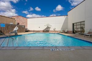 a large swimming pool in front of a building at Aggieland Boutique Hotel in College Station
