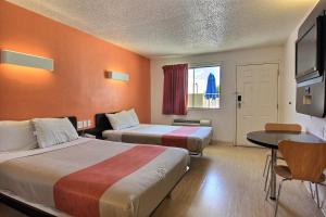 een hotelkamer met 2 bedden en een tafel bij Motel 6-Austin, TX in Austin