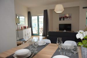 une salle à manger avec une table, des assiettes et des verres à vin dans l'établissement Wonderful Apartment Albufeira Marina 4B 2B, à Albufeira