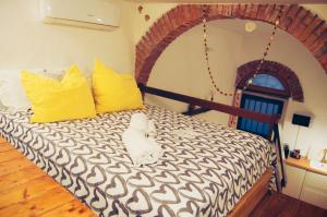 una camera da letto con un letto con cuscini gialli e bianchi di Il Soppalco a Corniglia