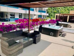 un patio con mesa, sillas y flores en Preciosos Apartamentos en Samaria Club de Playa sector Pozos Colorados, en Santa Marta