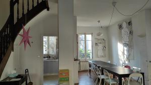 cocina y comedor con mesa y sillas en Grande maison ancienne simple et spacieuse. en Vichy