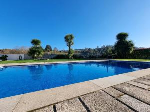 a swimming pool with blue water in a yard at Casa da Leira in Amarante