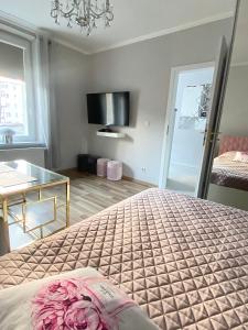 a bedroom with a bed and a glass table at Glamour Apartment przy plaży, z parkingiem prywatnym in Sopot