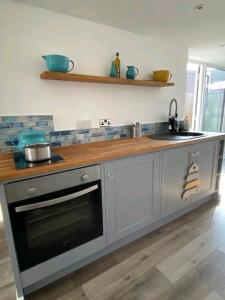 a kitchen with a stove and a sink and a counter at The Salty Bee in South Hayling