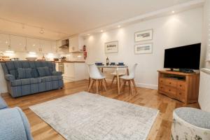 a living room with a couch and a table with a tv at Harbour House Apartment in Wadebridge