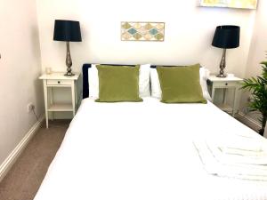 een slaapkamer met een wit bed en 2 nachtkastjes bij Luxury apartment in the heart of Bath in Bath