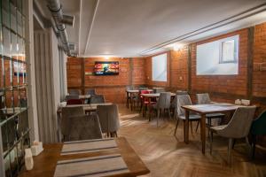 a restaurant with tables and chairs and brick walls at T&S Apart-Hotel in Chernivtsi