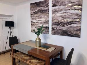 una mesa de comedor con un jarrón encima en Superbly located 2 bedroom luxury apartment, en Bath