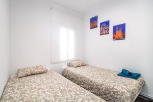 twee bedden naast elkaar in een kamer bij LOVELY APARTMENT Barca 2 in Barcelona