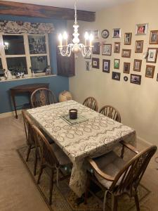 een eetkamer met een tafel met stoelen en foto's aan de muur bij The Master Suite, enjoy the countryside in style in Ashover