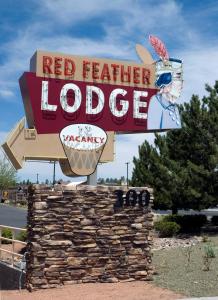 a sign for a red feather lodge on the side of a road at Red Feather Lodge/Hotel in Tusayan