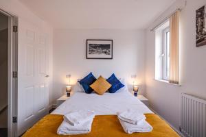 a bedroom with a white bed with blue pillows at Stanley Sparkle Stays - 4BRooms, 4Beds, Prkg, Wifi in Liverpool