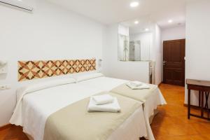 a bedroom with a bed with two towels on it at Arte de Cozina in Antequera
