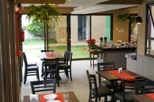 a dining room with tables and chairs in a restaurant at Hotel Pousada Marra in Catalão