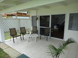 a patio with two chairs and a table on it at Betela Beach House in Rarotonga