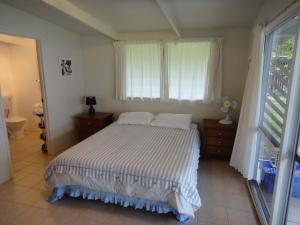 a bedroom with a bed and a window at Betela Beach House in Rarotonga
