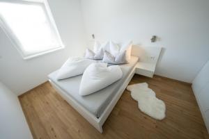 una camera con due letti con cuscini bianchi e una finestra di Austrian Apartments a Bad Goisern
