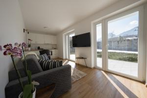 uma sala de estar com um sofá e uma grande janela em Austrian Apartments em Bad Goisern