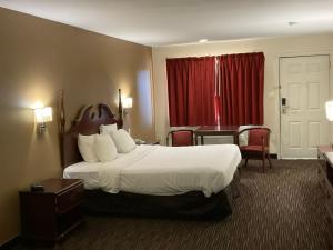 a hotel room with a large bed and a red window at Atlantic Inn in Pleasantville