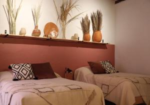 two beds in a room with plants on the wall at CASA DAMIANA in Lagos de Moreno