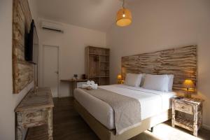 a bedroom with a large bed with a wooden headboard at Pousada Tubarão in Fernando de Noronha