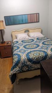 a bed with a blue and white comforter and a table at Beautiful and Cozy Homes in Cortland