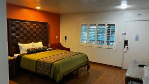 um quarto de hotel com uma cama e uma janela em New American Inn & Suites em Anaheim