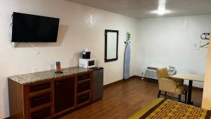 a room with a kitchen with a tv on the wall at New American Inn & Suites in Anaheim