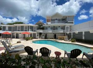 a large house with a swimming pool and chairs at Las Casitas de Village in Carolina
