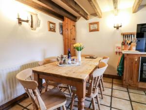 a dining room with a wooden table and chairs at Oak Tree Cottage in Matlock