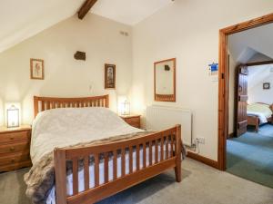 a bedroom with a wooden bed and a mirror at Oak Tree Cottage in Matlock