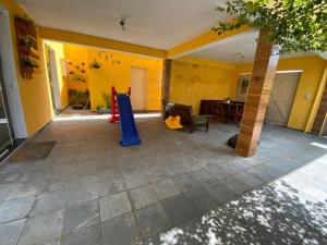 a play area with a slide in a house at Hostel Gratidão in Itanhaém