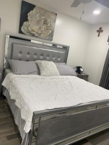 1 dormitorio con 1 cama grande con marco de plata en Blanquitas Home en Long Beach