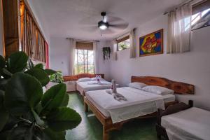 a room with four beds and a couch and a fan at Villas Jacquelina in Quepos