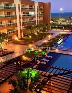 uma piscina de hotel com cadeiras e um edifício em Apartments Vg Fun Praia do Futuro em Fortaleza