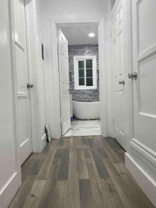 a hallway with a bathroom with a tub and a toilet at Blanquitas Home in Long Beach