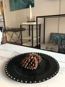 a pine cone on a black plate on a table at Olivos Puerto - La Isla in Olivos