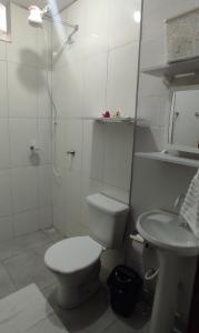 a bathroom with a toilet and a shower and a sink at Loft Pousada Sorriso in Sorriso