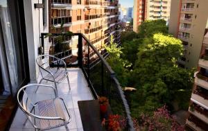 a balcony with two chairs and a view of a city at Olivos Puerto - La Isla in Olivos