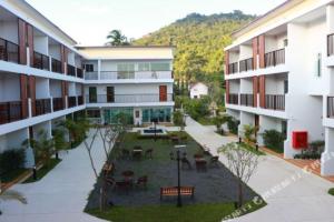 an apartment complex with a courtyard with tables and chairs at Crystal Lamai Hotel in Lamai