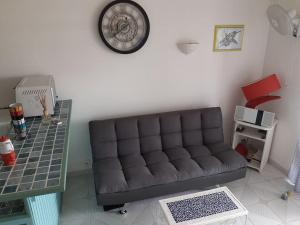 uma sala de estar com um sofá e um relógio na parede em BEAU STUDIO DUPLEX em Les Trois-Îlets