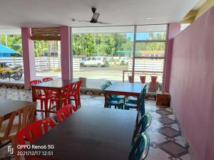 a restaurant with tables and chairs and a view of a street at HOTEL ANISH in Havelock Island