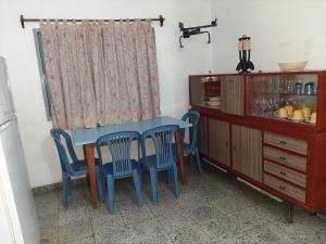 a kitchen with a blue table and chairs and a cabinet at La Viñita in Cafayate