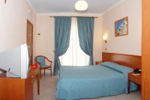 una camera con un letto blu e una finestra di Hotel Residence Tramonto a Rodi Garganico
