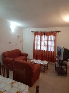 a living room with a couch and a tv at La Viñita in Cafayate