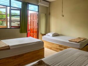 a bedroom with two beds and a window at Echo Beach Hostel in Ban Tai