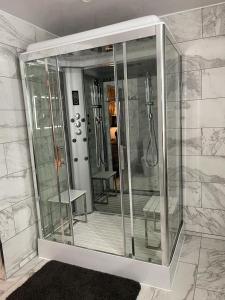 a bathroom with a glass shower with a mirror at Olivia House in Porthcawl