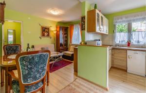 uma cozinha e sala de jantar com paredes verdes e uma mesa em Nice Apartment In Premantura With Wifi em Premantura